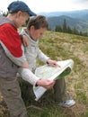 Traveling people reading map on mountains Royalty Free Stock Photo