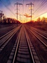 Traveling on railroad train tracks into setting sunlight on the distant horizon Royalty Free Stock Photo