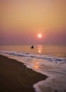 Fishermen coming back by boat to sea beach during early morning Sunrise time from the ocean. Royalty Free Stock Photo
