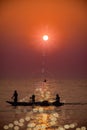 Fishermen coming back by boat to sea beach during early morning Sunrise time from the ocean. Royalty Free Stock Photo