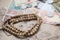 Traveling retro still life closeup with map, money, coins, buddhist mala bracelet. Royalty Free Stock Photo