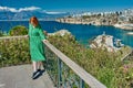 Traveling to Turkish resort Antalya in spring in March, young woman stands on observation platform above Mediterranean