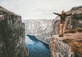 Traveling woman standing on cliff over fjord alone