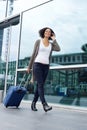 Traveling woman walking with suitcase and mobile phone Royalty Free Stock Photo