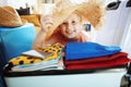Traveller girl with beach straw hat packing for summer travel Royalty Free Stock Photo