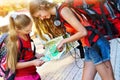 Traveller girls with backpack looking for way tourist paper map