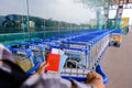 Traveller with hand on luggage trolley in airport, holding passport, mask, boarding pass, map Royalty Free Stock Photo