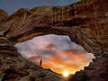 A traveller hiking a beautiful desert scenic landscape during sunrise or sunset North Window arch at Arches National Park in Utah. Royalty Free Stock Photo