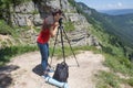 Traveller looking the nature from the high mountain with spotting scope, binoculars tripod