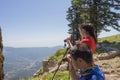 Traveller is looking the nature from the mountain with binoculars tripod