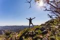 Traveller man with arms spread overlooking mountain view