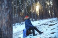 Traveller man in a blue winter jacket ad red cap in the woods. Sandy bay, Baikal lake, winter time