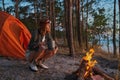 Traveller sitting beside burning fire in the woods Royalty Free Stock Photo