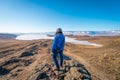 A traveller standing on top of mountain and looking to Baikal frozen lake in winter season, Olkhon island, Siberia, Russia