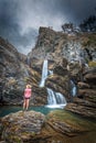 Traveller stands in awe, moody skies, limestone cliffs, waterfalls and blue waterholes Royalty Free Stock Photo