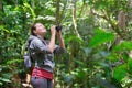 Traveller watching through binoculars wild birds in the jungle. Royalty Free Stock Photo