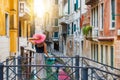 Traveller woman enjoys the view to a canal with passing by gondola in Venice, Italy Royalty Free Stock Photo