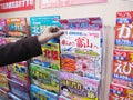 Traveller woman hand select and buy Japanese magazine at bookstore in Kyoto railway station, Japan Royalty Free Stock Photo