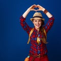 Traveller woman isolated on blue showing heart shaped hands