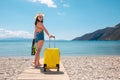 Traveller woman with a suitcase and flippers on the beach Royalty Free Stock Photo