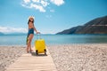 Traveller woman with a suitcase and flippers on the beach Royalty Free Stock Photo
