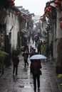 The travellers walking along Yuehe street in the rain