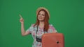 Woman traveller in straw hat pointing at the empty area, holding suitcase. Space to insert advertising. Isolated on Royalty Free Stock Photo