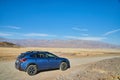 Travelling with a blue Subaru Crosstrek on a desert road through the mountains of Death Valley