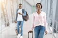 Travelling Concept. Happy Man And Woman Walking At Airport Terminal With Luggage Royalty Free Stock Photo