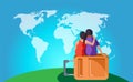 Travelling couple sitting on bag and looking world map