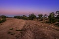 Travelling through a dry river bed landscape covered in acacia trees at sunset, Kruger National Park, Royalty Free Stock Photo