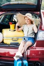 travelling girl sitting in car trunk Royalty Free Stock Photo