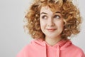 Travelling in her dreams. Portrait of attractive dreamy girl with cute curly hair looking at upper left corner and Royalty Free Stock Photo