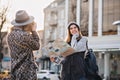 Travelling in sunny big city of fashionable joyful gilrs. Taking photo, enjoying vacation, travel with backpack, citymap Royalty Free Stock Photo