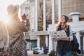 Travelling in sunny big city of fashionable joyful gilrs. Taking photo, enjoying vacation, travel with backpack, citymap Royalty Free Stock Photo