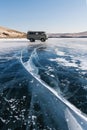 Travelling in winter at frozen lake Baikal in Siberia, Russia. Tourist van parking on ice with cracked line Royalty Free Stock Photo