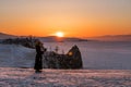 Travelling in winter at lake Baikal in Irkutsk, Russia. Winter landscape in sunset with young woman using mobile smart phone and e Royalty Free Stock Photo