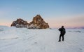 Travelling in winter, photographer carrying camera tripod at frozen lake Baikal in Siberia, Russia Royalty Free Stock Photo