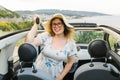 Travelling woman holding keys to new car and smiling at camera - ownership and purchase automobile concept