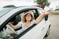 Travelling woman holding keys to new car and smiling at camera - ownership and purchase automobile concept