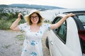 Travelling woman holding keys to new car and smiling at camera - ownership and purchase automobile concept