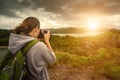 Travelling woman photographer with backpack making an inspiring Royalty Free Stock Photo