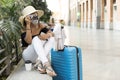 Travelling woman taking a photograph with an analogue camera inside a transport station. Space for text