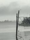 Trawling boat docked in Plaquemines Parish Louisiana on a foggy morning.