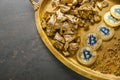 Tray with bitcoins and gold nuggets on grey background