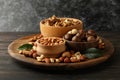 Tray with bowls with different nuts on wooden background