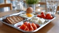 Tray with breakfast including egg, toast, cheese, and tomatoes Royalty Free Stock Photo