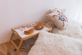 Tray with breakfast on table near bed in bedroom. Fresh croissants on the breakfast table on the bed