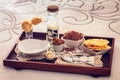 Tray with continental breakfast on hotel bed made of cereals, chocolate, cakes and a bowl with spoon. Breakfast in bed. Front view Royalty Free Stock Photo