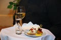 Tray, covered with a white table cloth, with a glass of wine, takan with water and a plate of snacks in the waiter's hand